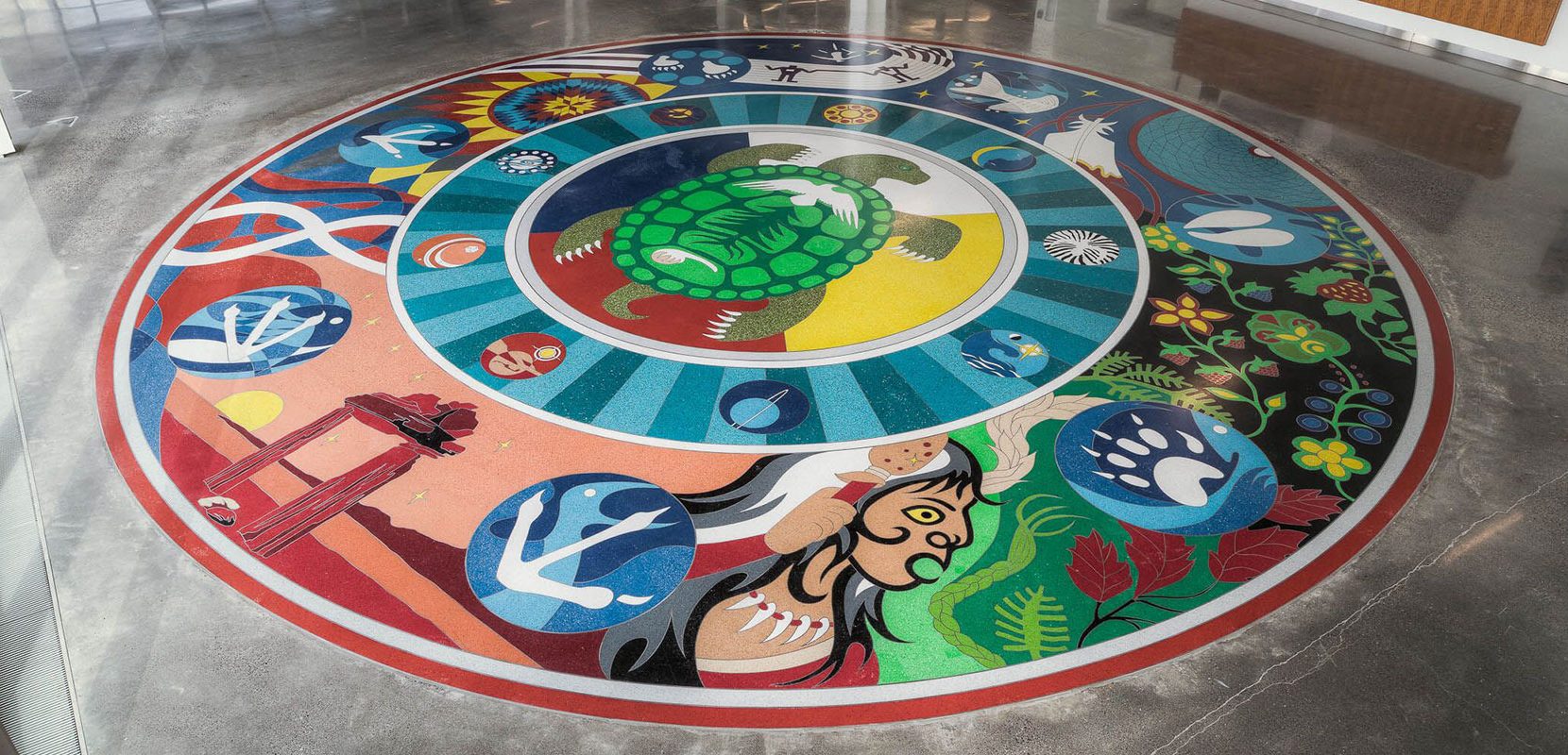 A terrazzo medallion created by Indigenous artist Joseph Sagaj at Seneca College.